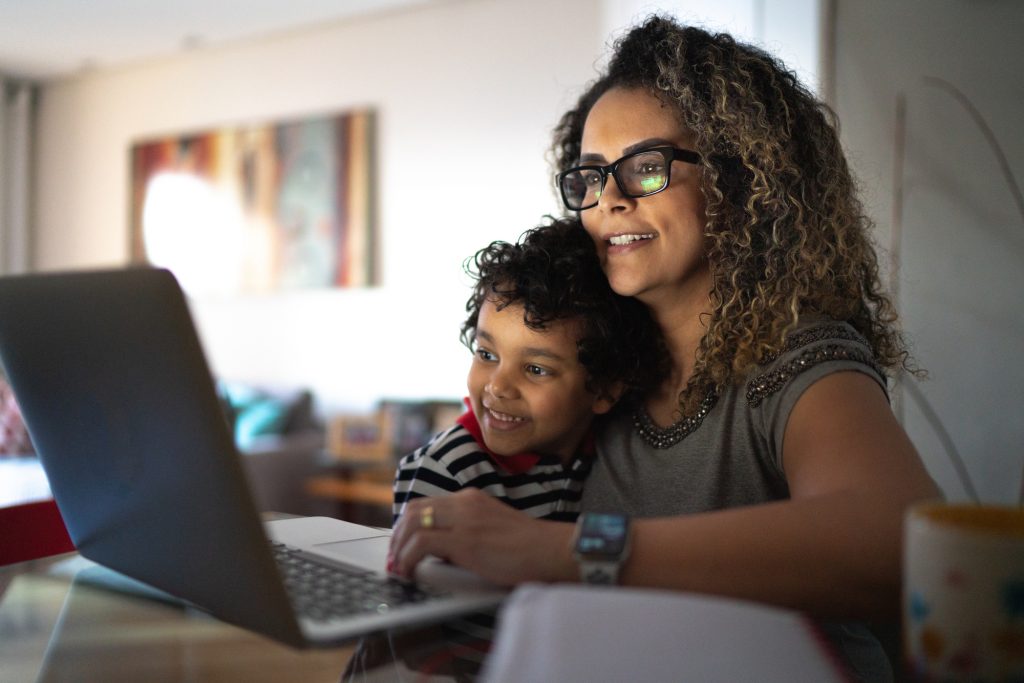 Woman looking at laptop with son on her lap